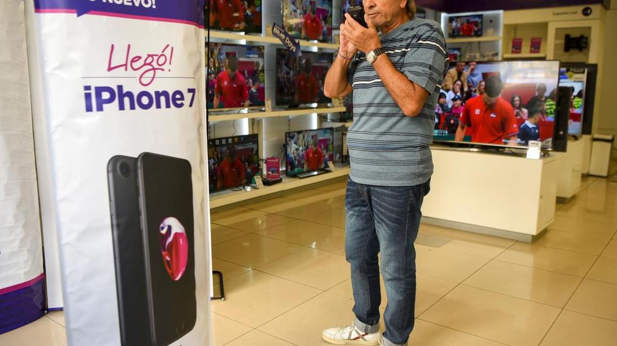 Un hombre habla por su teléfono el viernes en una tienda donde anuncian la llegada del nuevo iPhone, en Buenos Aires, Argentina.