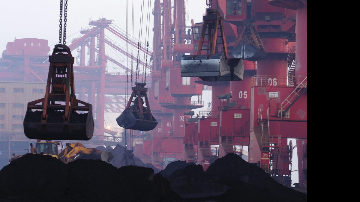 
Maquinaria pesada para cargar mineral de hierro en un puerto de Rizhao, en la provincia de Shandong, China.
