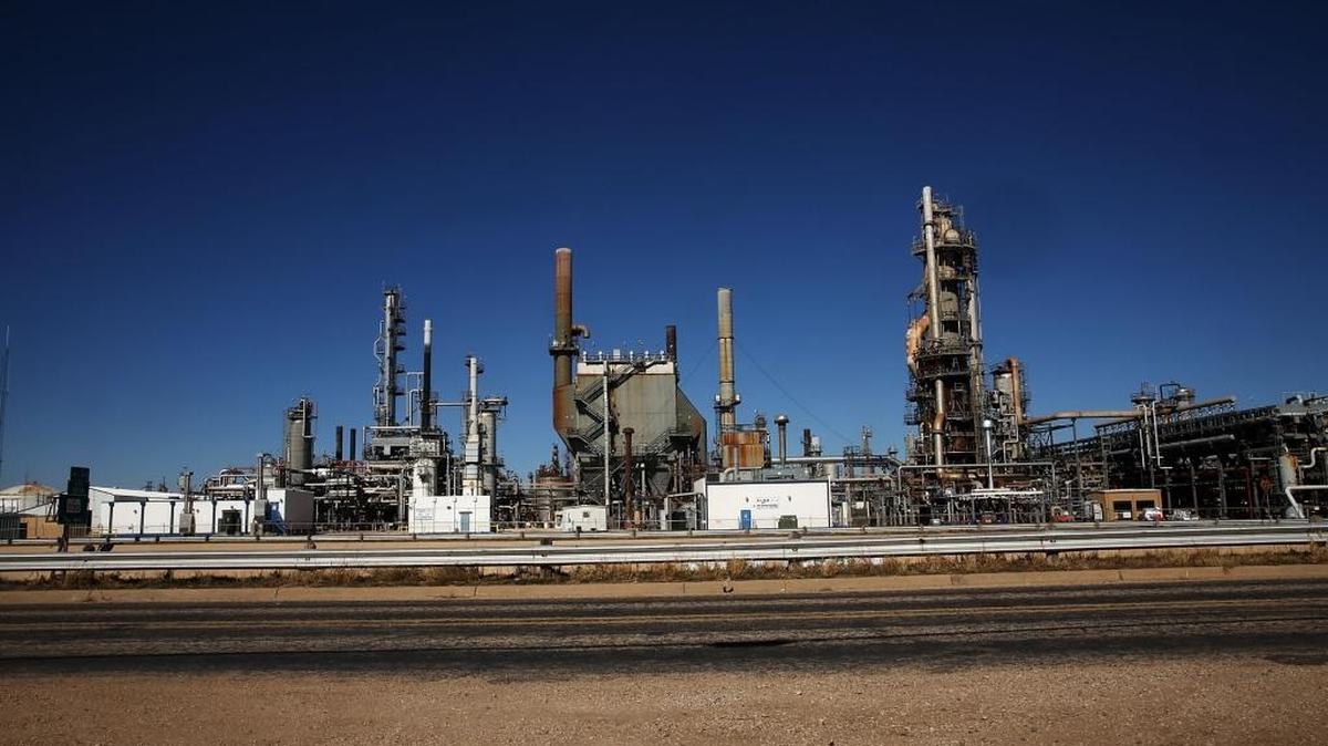 Vista de una refinería petrolera cerca de una autopista en Big Srping, Texas. La AIE dijo el martes que no percibe un alza en los precios del petróleo, a corto plazo.