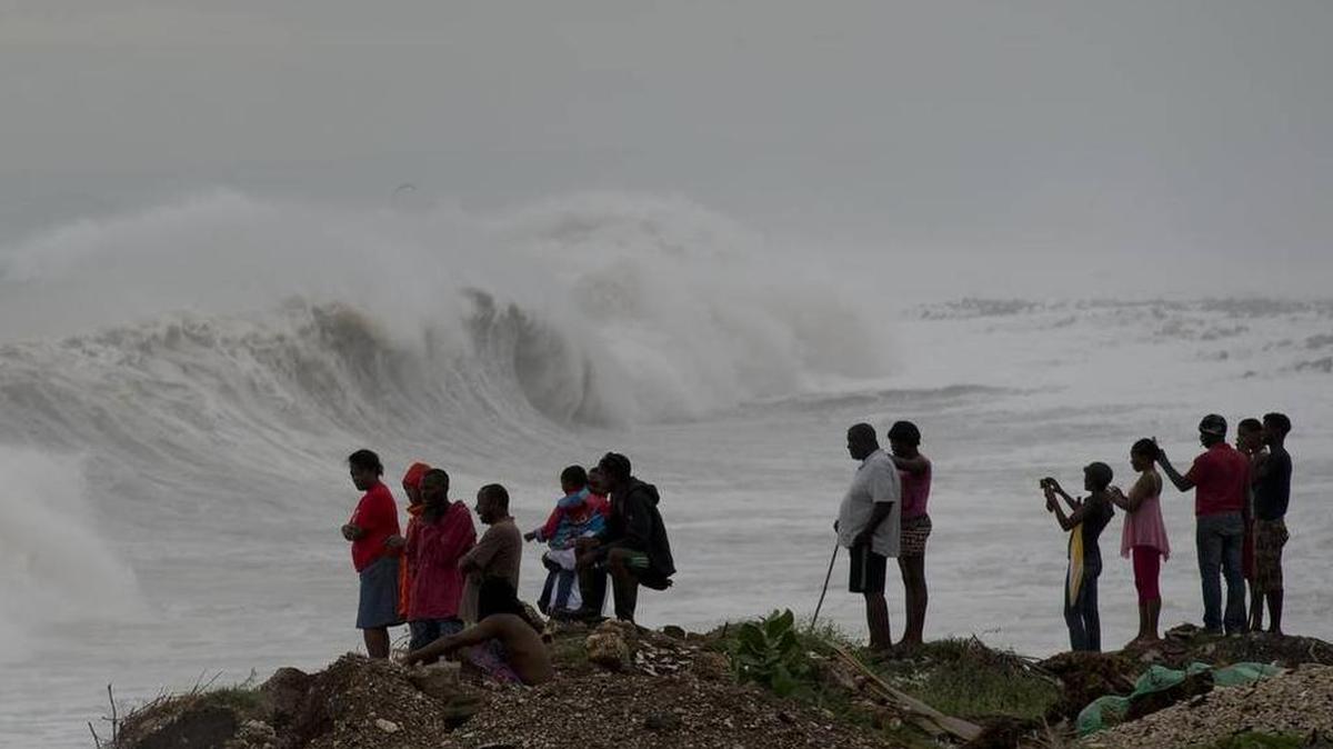 Personas observan el fuerte oleaje causado por el huracán Matthew el año pasado en Jamaica.