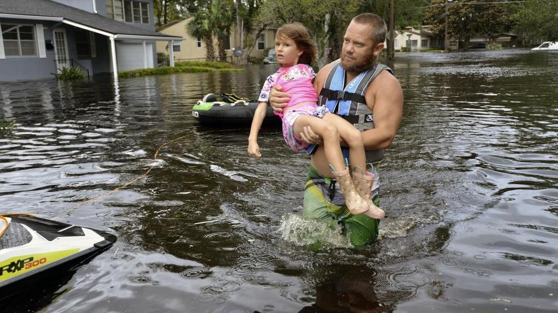 Tommy Nevitt traslada a Miranda Abbott, de 6 años, el 11 de septiembre de 2017 por una zona de Jacksonville inundada por el huracán Irma a su paso por Florida.