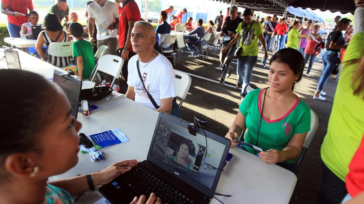 Panameños asisten el domingo a retirar sus boletos en el estacionamiento de un centro comercial para acceder al acto inaugural del Canal de Panamá ampliado.