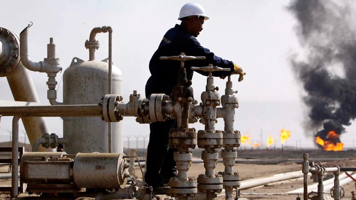 Un trabajador petrolero opera válvulas en una refinería de petróleo, en Bagdad, Iraq.