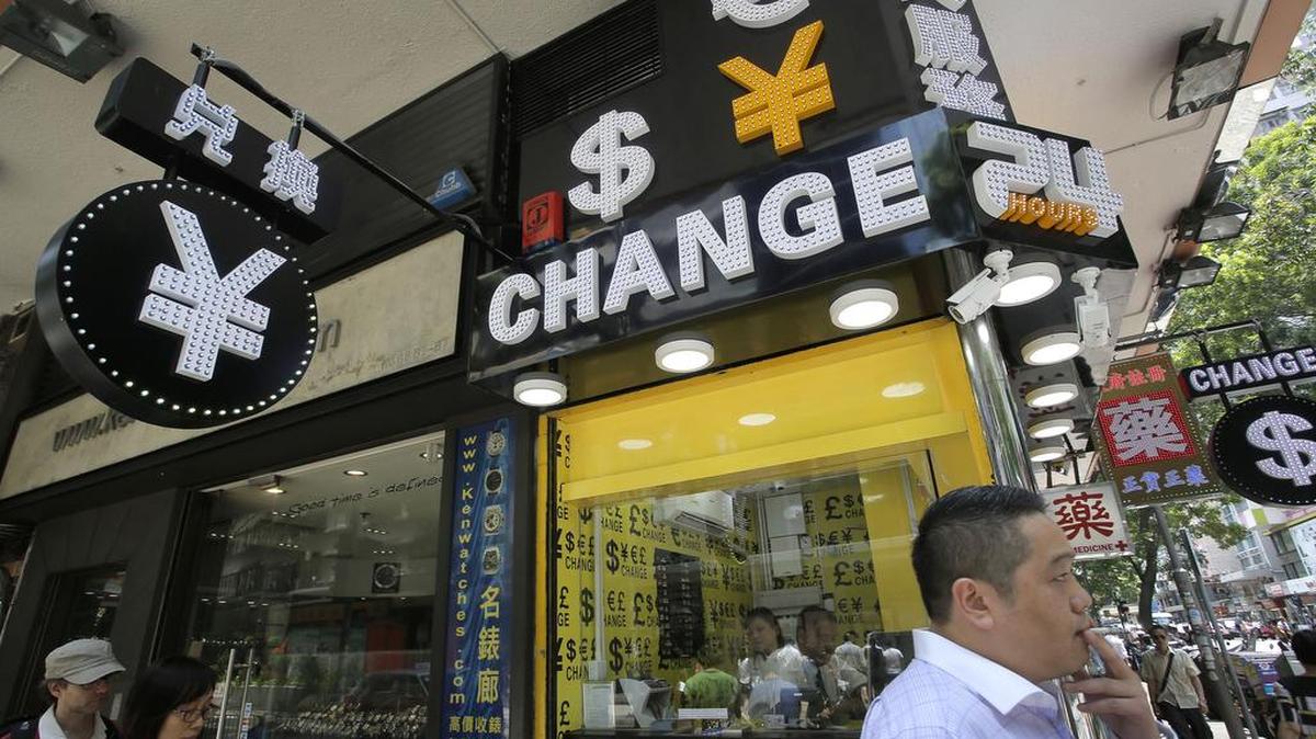 
Un hombre pasa frente a una casa de cambio de divisas en Hong Kong el martes, día en que china anunciara la devaluación de su moneda.


