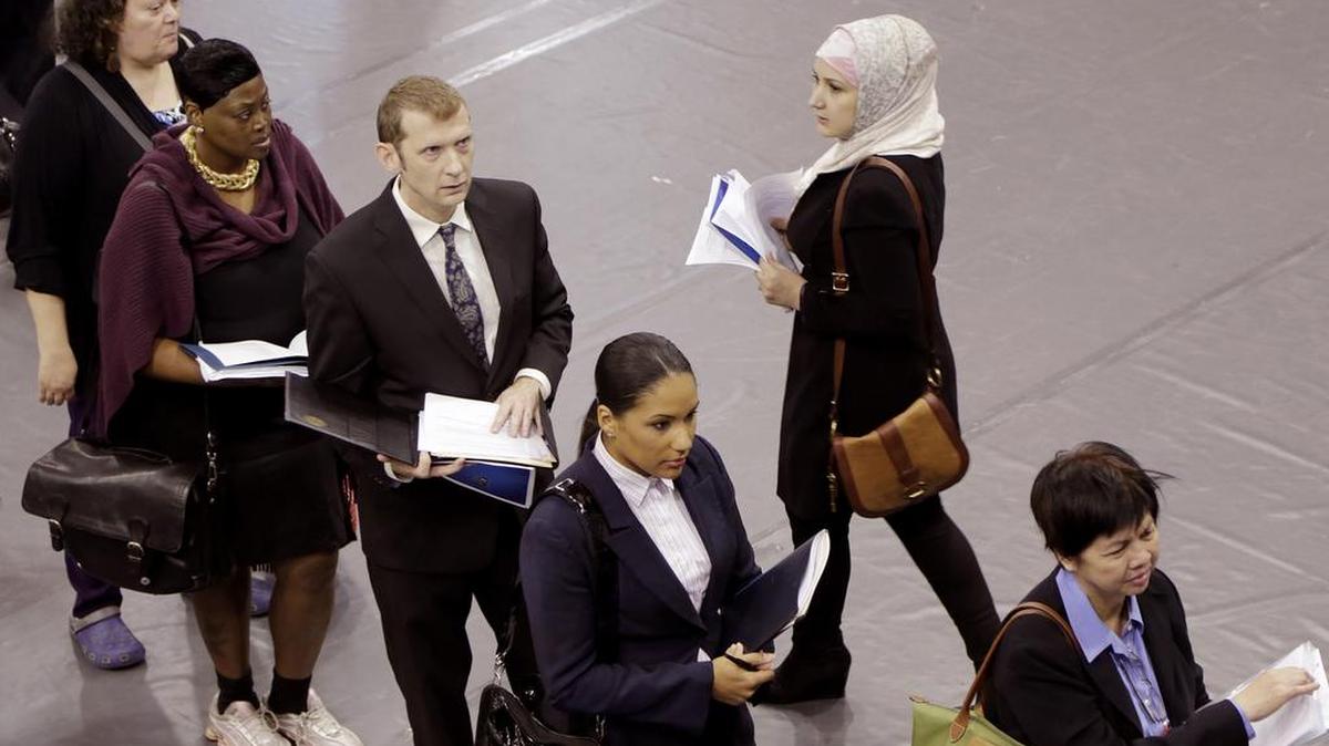 Personas hacen fila para una entrevista en una feria de trabajo en Nueva York. EEUU.