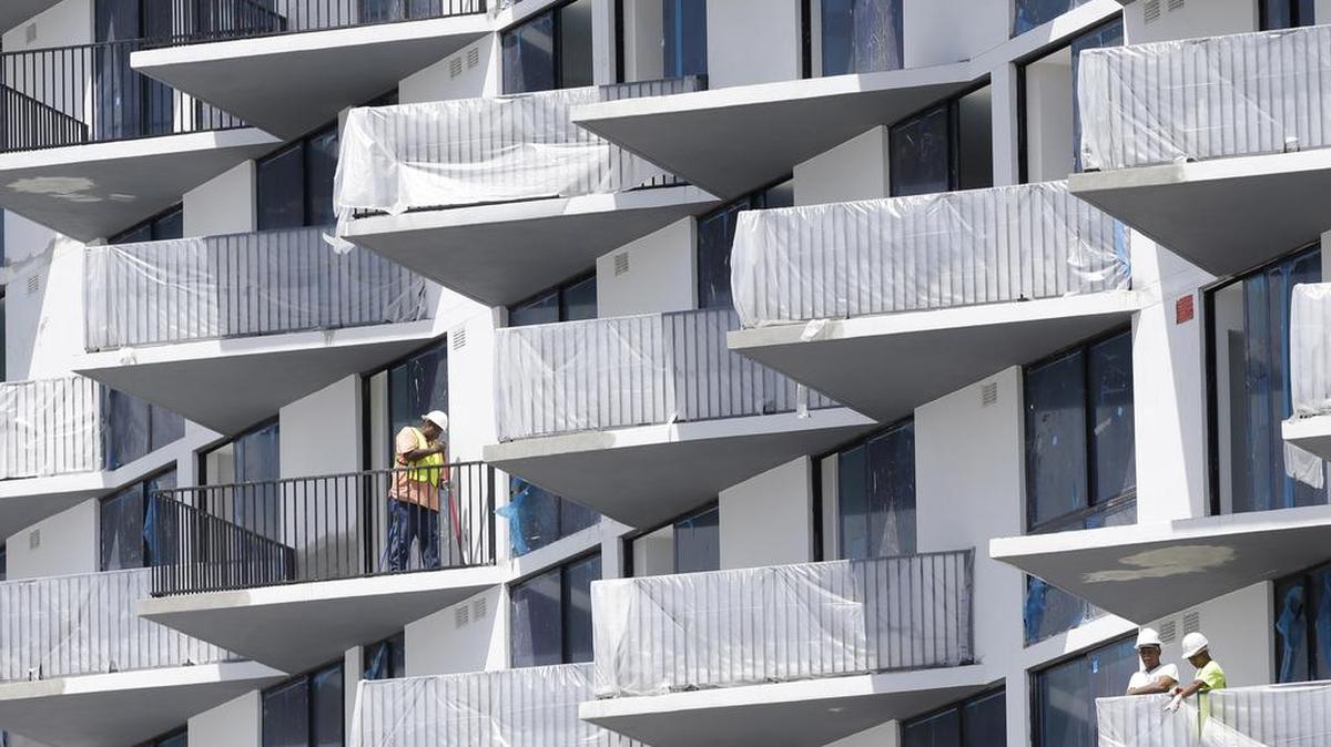 
Un obrero trabaja en el balcón de un complejo de apartamentos en construcción en Doral.


