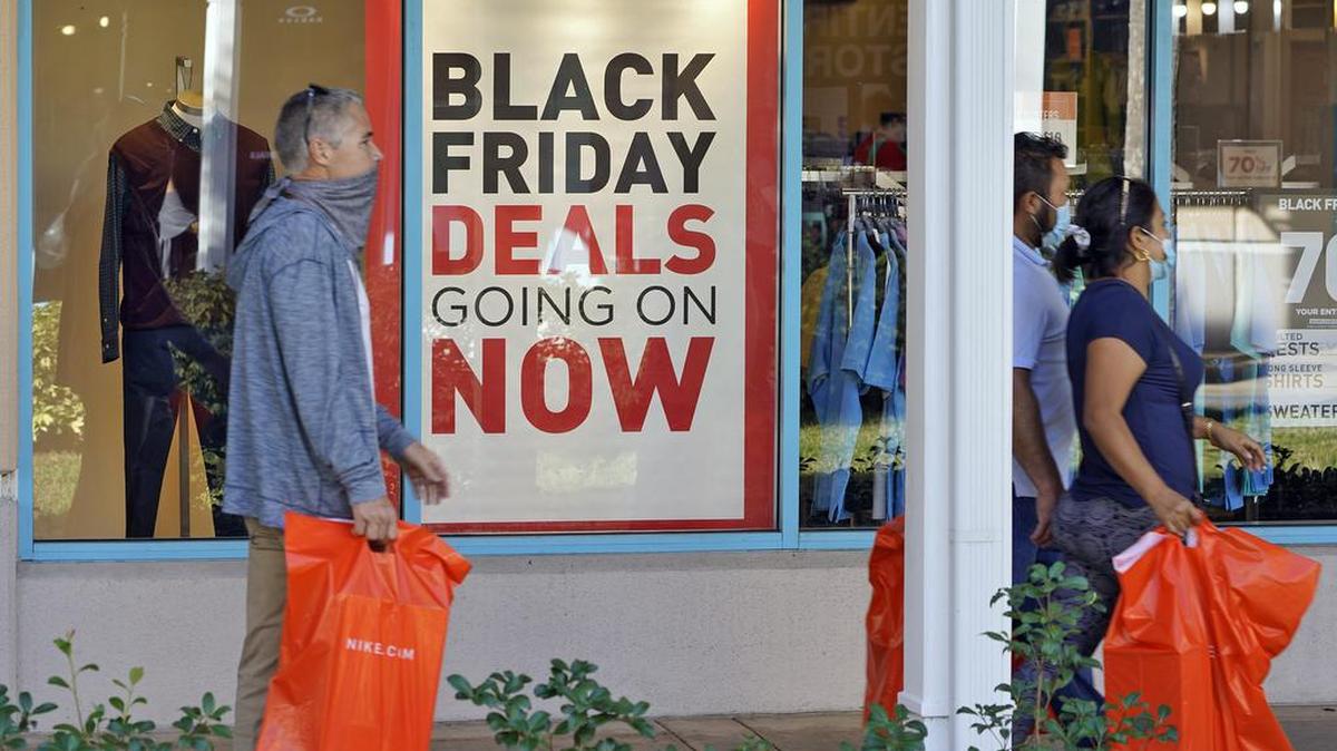 Archivo - Compradores usan máscaras protectoras mientras buscan ofertas del Viernes Negro en las tiendas Ellenton Premium Outlet el viernes 27 de noviembre de 2020 en Ellenton, Florida. Christine Whelan, profesora clínica en el departamento de ciencia del consumidor de la Universidad de Wisconsin. -Madison, recomienda revisar sus finanzas para determinar cuánto puede gastar en compras navideñas. Cree también una lista de destinatarios de regalos. Con esta información, tendrá una idea de cuánto gastar en cada persona.