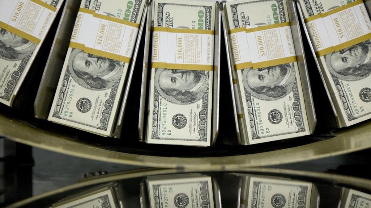 Fajos de billetes de cien dólares pasan a través de una máquina de circulación en la Oficina de Grabado e Impresión, en Washington DC.