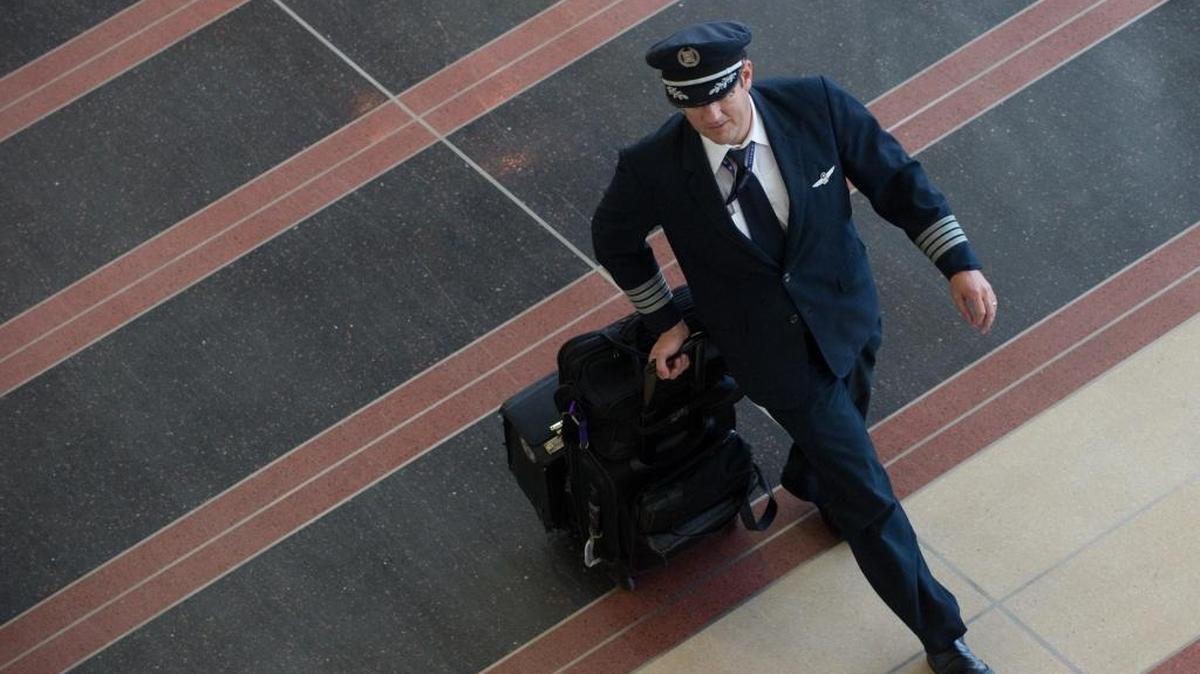 Un piloto camina por una terminal en el aeropuerto Ronald Reagan en Virginia. Las aerolíneas medianas y regionales de EEUU están sufriendo una escasez de pilotos que amenaza la salud de la industria de la aviación norteamericana.