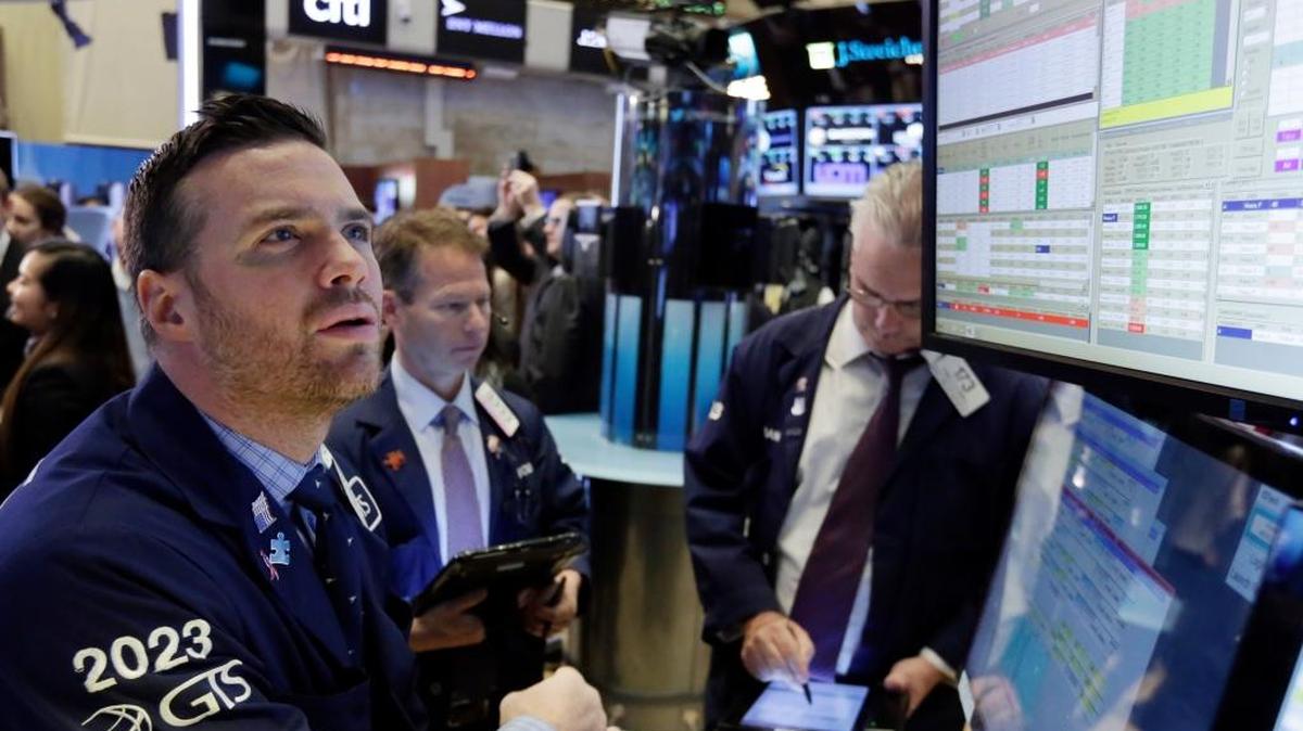El especialista bursátil Frank Masiello (izq.), observa el lunes el movimiento de las acciones en la Bolsa de Valores de Nueva York, que cerró con significativas alzas.