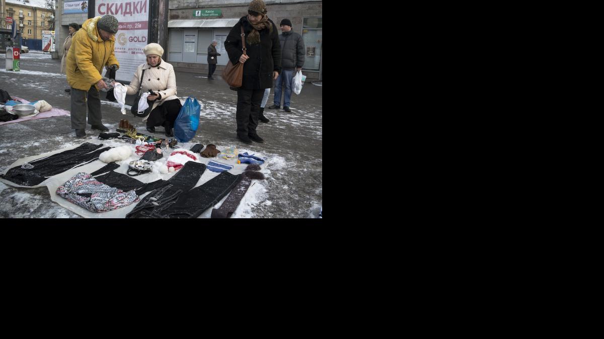
Una mujer compra ropa usada en una calle de San Petersburgo. Con la caída del rublo los rusos están optando por extender el rendimiento de su dinero.
