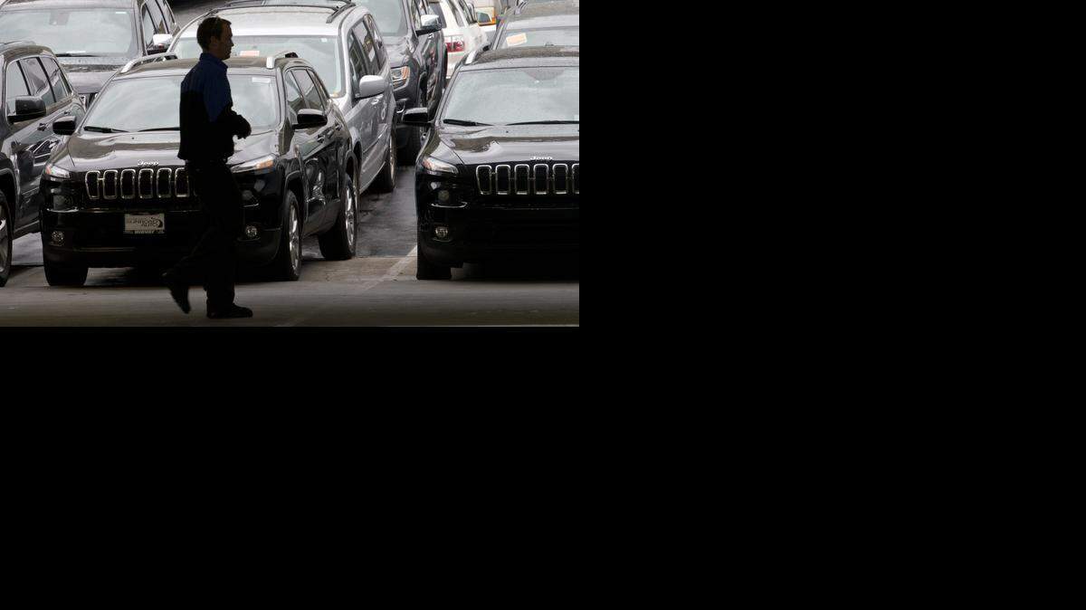 
Un empleado de un concesionario de Chrysler en San Diego, camina por el patio de estacionamiento de vehículos el martes.
