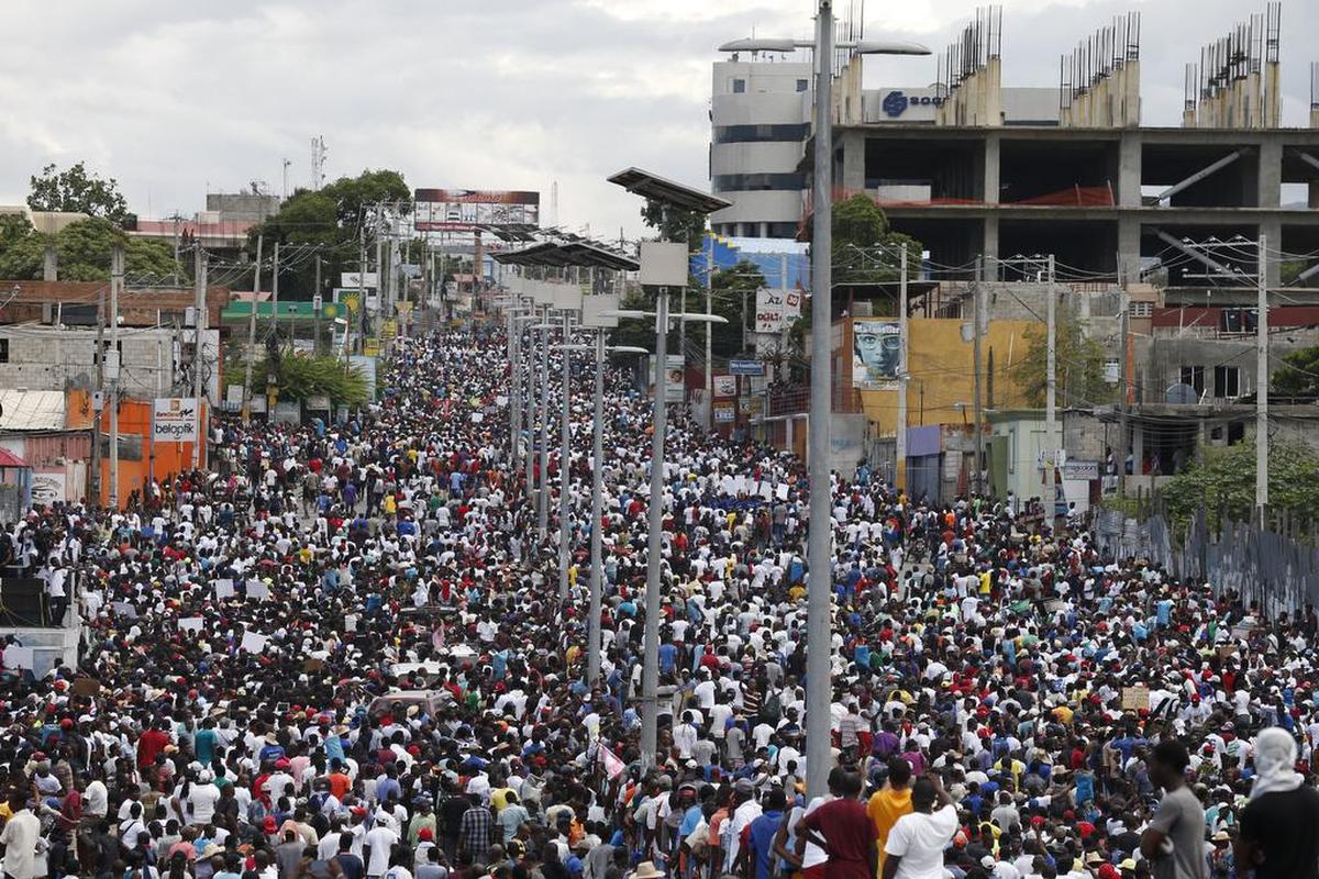 Thousands of protesters fill the road during a mostly peaceful march called by the artist community, in Port-au-Prince, Haiti, Sunday, Oct. 20, 2019. Anger over corruption, inflation and scarcity of basic goods, including fuel, has led to nearly two months of demonstrations that have paralyzed the country as protesters demand the resignation of President Jovenel Moise.