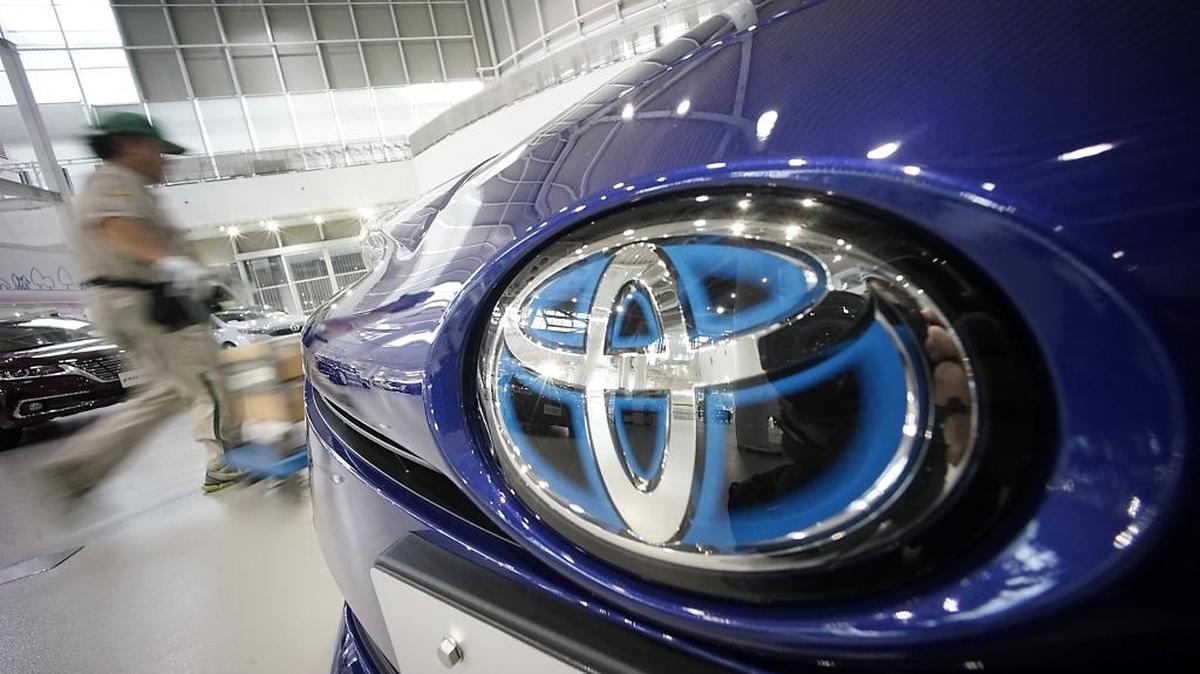 Un trabajador pasa cerca de un vehículo Toyota, el miércoles, en una exhibición.