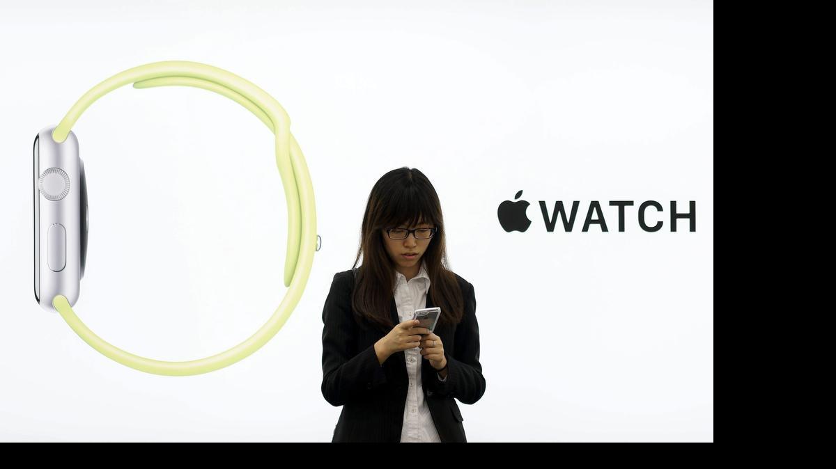 
Una joven permanece junto a un anuncio del Apple Watch, el viernes 24 de abril, que salió a la venta ese día en una tienda de Tokio, Japón. El reloj inteligente de Apple, el Apple Watch, se vende en tres modelos distintos con precios de entre $349 y más de $10,000.
