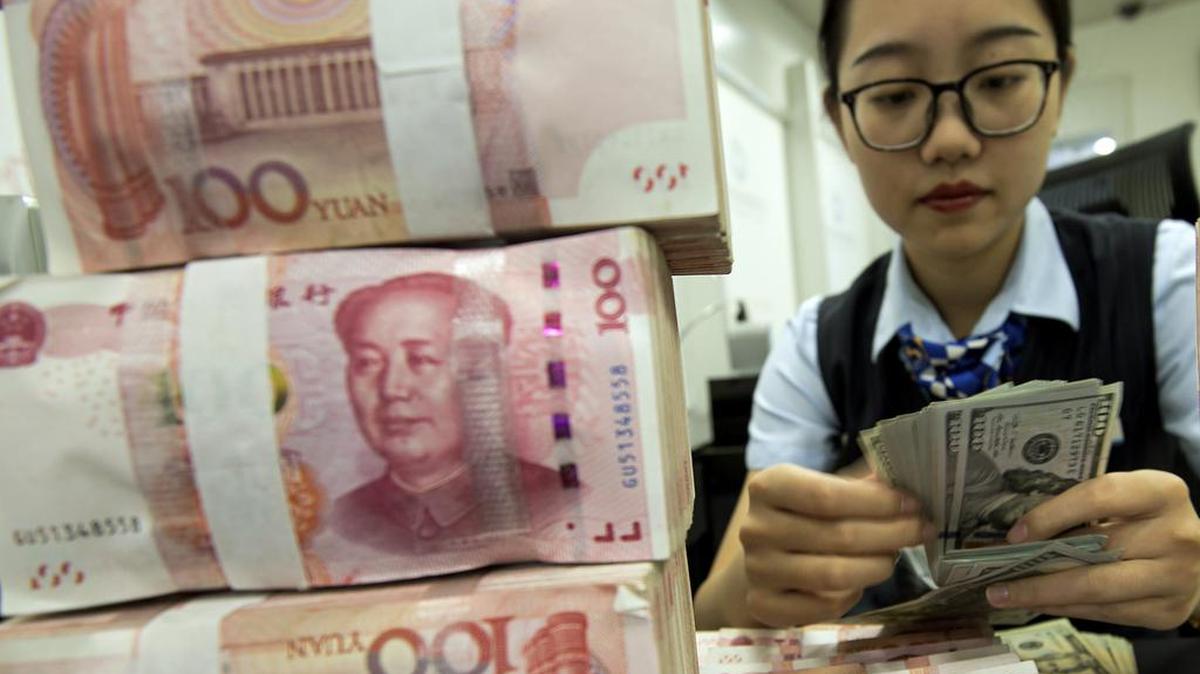 Una empleada cuenta dólares y yuanes este martes en una sucursal bancaria en la ciudad china de Hai'an al este del país.