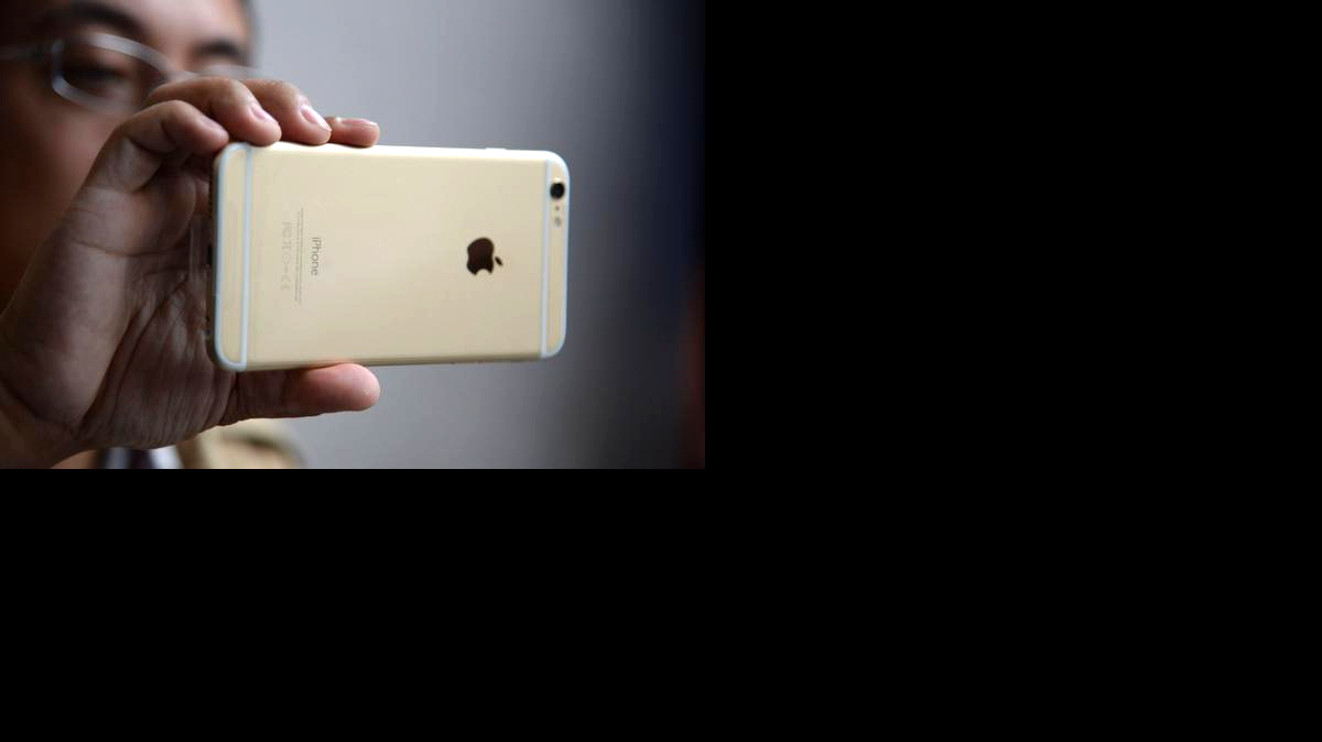 
Un hombre chequea su iPhone 6 Plus frente a una tienda apple de Pasadena, california. Una nueva familia de malware está diseñada para dañar a los iPhones.

