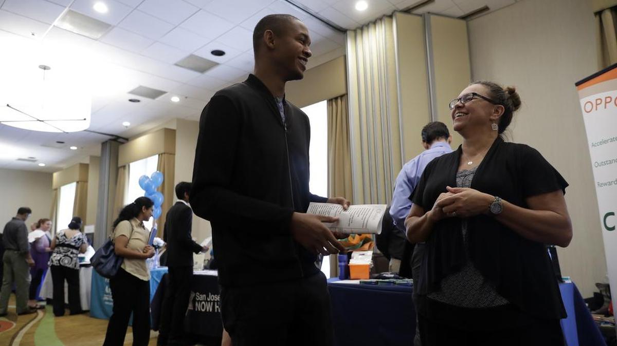 Kathy Tringali (der.), una reclutadora de trabajadores para Big 5 Sporting Goods, habla con Jarrell Palmer el 24 de agosto durante una feria de trabajo en California.