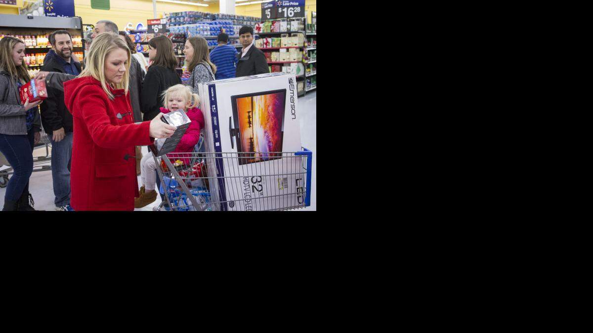 
Liz Richardson, izquierda, y su hija Aubrey, de 2 años, lleva un televisor de 32 pulgadas en su carrito de compras de Walmart en Bentonville, Arkansas.
