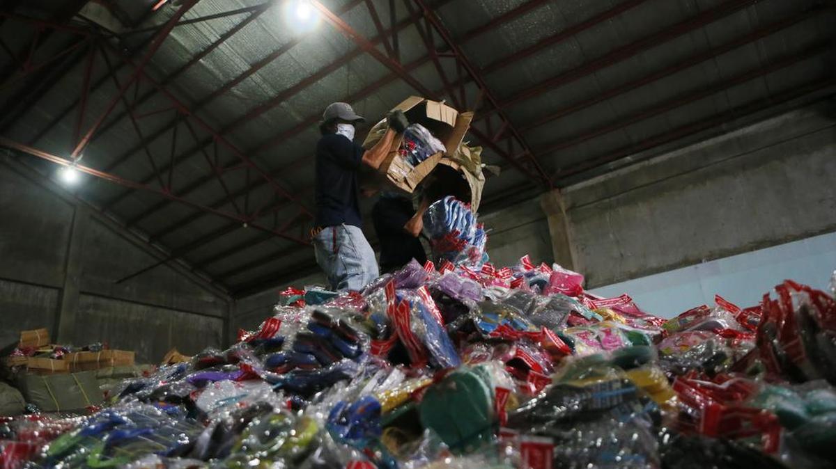 Trabajadores descargan productos piratas, en su mayoría zapatillas de goma y sandalias, para la trituración en un depósito aduanero en Filipinas. EEUU el miércoles sacó a Ecuador de la lista negra de de violación de los derechos de propiedad intelectual.