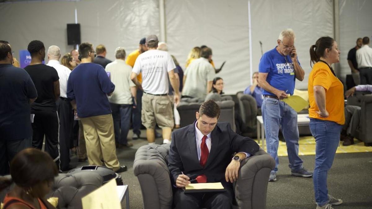 Personas que buscan empleo esperan para registrarse en una feria de trabajo de Amazon en Robbinsville, Nueva Jersey, el 2 de agosto de 2017.