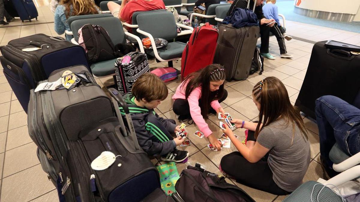 Niños juegan cartas el 22 de enero de 2016 en el Aeropuerto Internacional de Orlando.