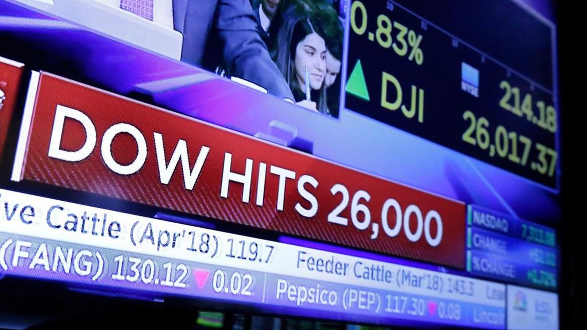 Una pantalla de televisión en el piso de la Bolsa de Valores de Nueva York titula anuncia que el Dow Jones alcanza los 26,000 puntos por primera vez.