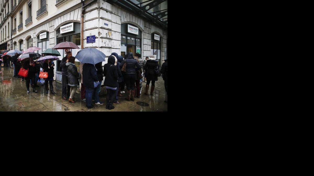 
Una larga fila de personas ansiosas por cambiar sus francos por euros se forma el viernes frente a una casa de cambio de divisas en Ginebra.
