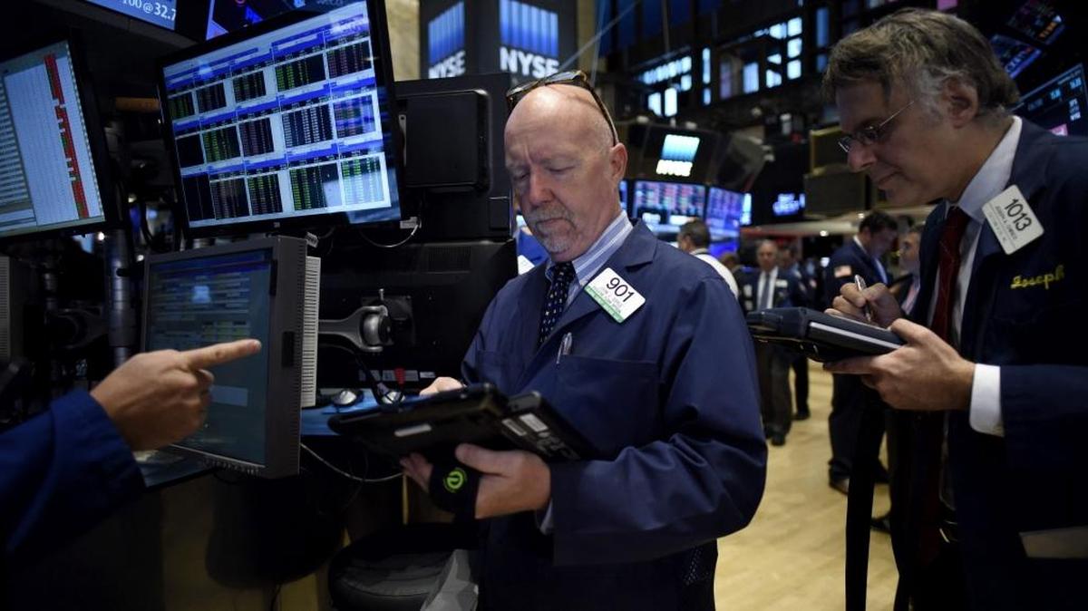 
Agentes de cambio y bursátiles operan en el parqué neoyorquino en Estados Unidos el martes. Wall Street cerró con fuertes pérdidas por las dudas en los mercados sobre el crecimiento global. 

