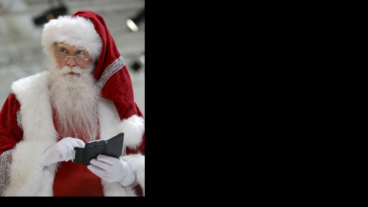 
Santa Claus revisa su teléfono inteligente durante el evento de Neiman Marcus Christmas Book, el martes en Dallas, Texas.
