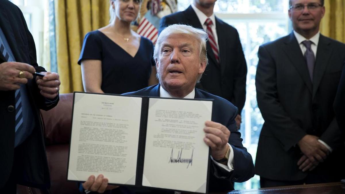 El presidente Donald Trump muestra el jueves el artículo 232 de la Ley de Expansión Comercial de 1962, que le otorga autoridad para fijar barreras a las importaciones de ciertos productos por razones de seguridad nacional.