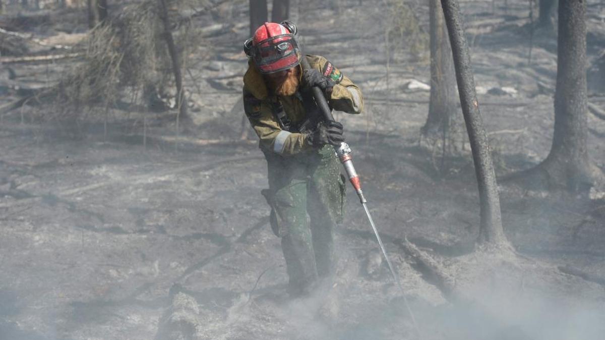 Un bombero forestal de Alberta en Hinton, en la zona de Parsons Creek en Fort Murray, Canadá. Las principales compañías petroleras que operan en Canadá se reunieron el martes con las autoridades para evaluar el daño que ha causado a sus operaciones el masivo incendio forestal que ha golpeado el noroeste del país.