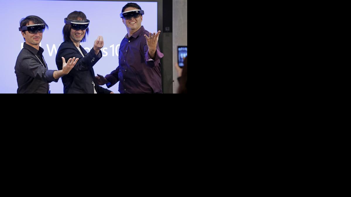 
Joe Belfiore, izquierda, Alex Kipman, y Terry Myerson, de Microsoft, sonríen mientras llevan en sus cabezas los lentes de Hololens, durante la presentación de Windows 10 en redmond, Washington.
