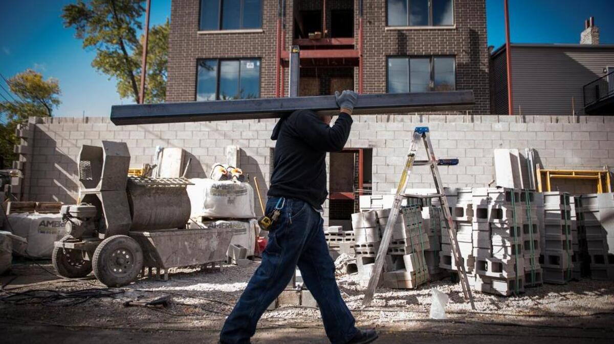 Un contratista lleva una viga de soporte de acero para un condominio en construcción en Chicago, Illinois.
