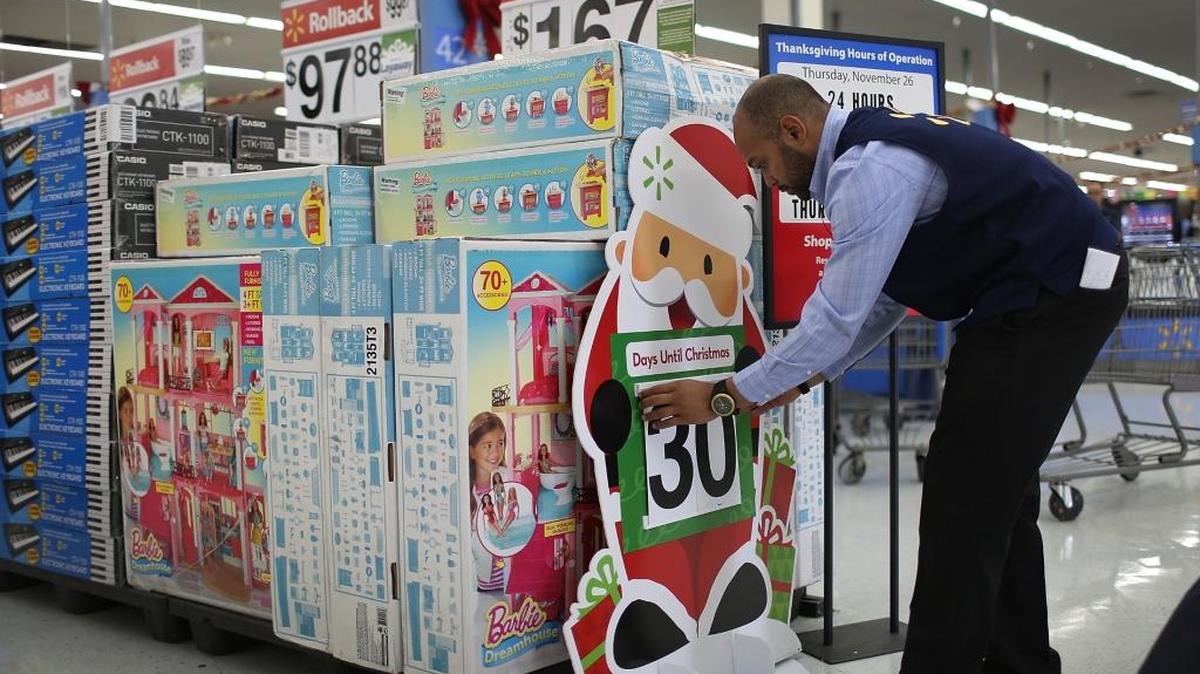 Jonathan Mary arregla un cartel en una tienda de Walmart el martes, como parte de los preparativos para el Black Friday o Viernes Negro.