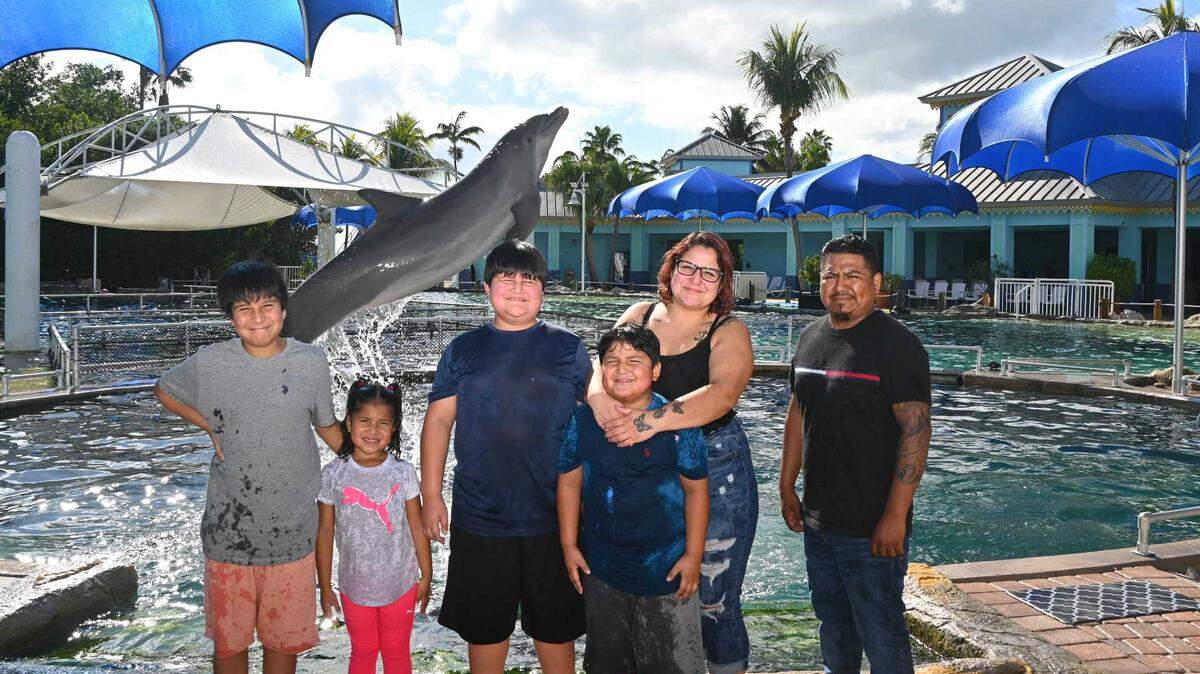 Pedro Vásquez, de 11 años, Aubrey Vásquez, de cinco, Jayden Vásquez, de nueve, Mario Vásquez, de ocho, y su madre Laura Canchola con un amigo de la familia, Rafael García, en el Miami Seaquarium en diciembre de 2022 después de que el Wish Book del Miami Herald y el Nuevo Herald publicaran la historia de la familia. La atracción le ofreció a la familia un día en el parque.