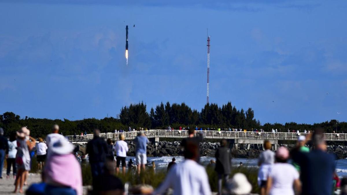 Las multitudes en la playa observan el aterrizaje del propulsor en la Zona de aterrizaje 1 en la Estación de la Fuerza Espacial de Cabo Cañaveral, Florida, el jueves 13 de enero de 2022. El SpaceX Transporter-3 se lanzó desde el Complejo de lanzamiento 40 en la Estación de la Fuerza Espacial de Cabo Cañaveral a las 10: 25 am jueves por la mañana. (Malcolm Dinamarca/Florida Today vía AP)