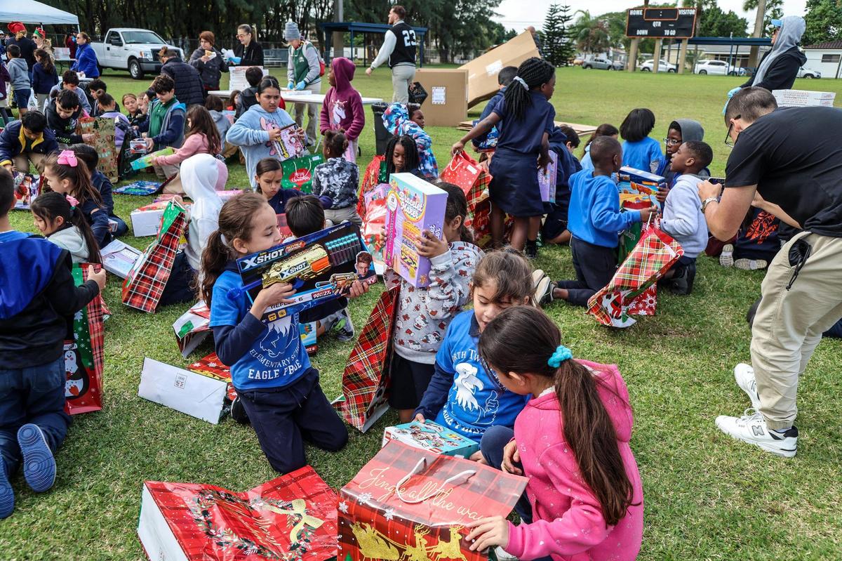 Estudiantes de 16 escuelas primarias de la ciudad de Hialeah abrieron los regalos entregados por Santa y la Sra. Claus después de llegar en helicóptero durante un evento de recolección de juguetes en el parque del Centro de Arte y Entretenimiento del Milander, el miércoles 6 de diciembre de 2023.