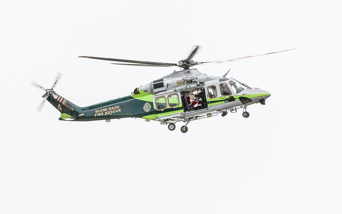 Santa y la Sra. Claus llegan en helicóptero para saludar y entregar regalos a estudiantes de diferentes escuelas de la ciudad de Hialeah durante un evento de colecta de juguetes en el parque del Centro de Arte y Entretenimiento del Milander, el miércoles 6 de diciembre de 2023.