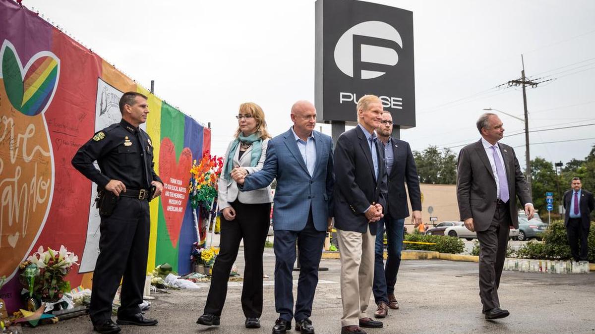 El compañero de fórmula de Hillary Clinton, Tim Kaine (a la derecha) visita un sitio conmemorativo en el club Pulse, el club en el que 49 personas murieron en un tiroteo masivo en junio, el lunes 26 de septiembre de 2016.