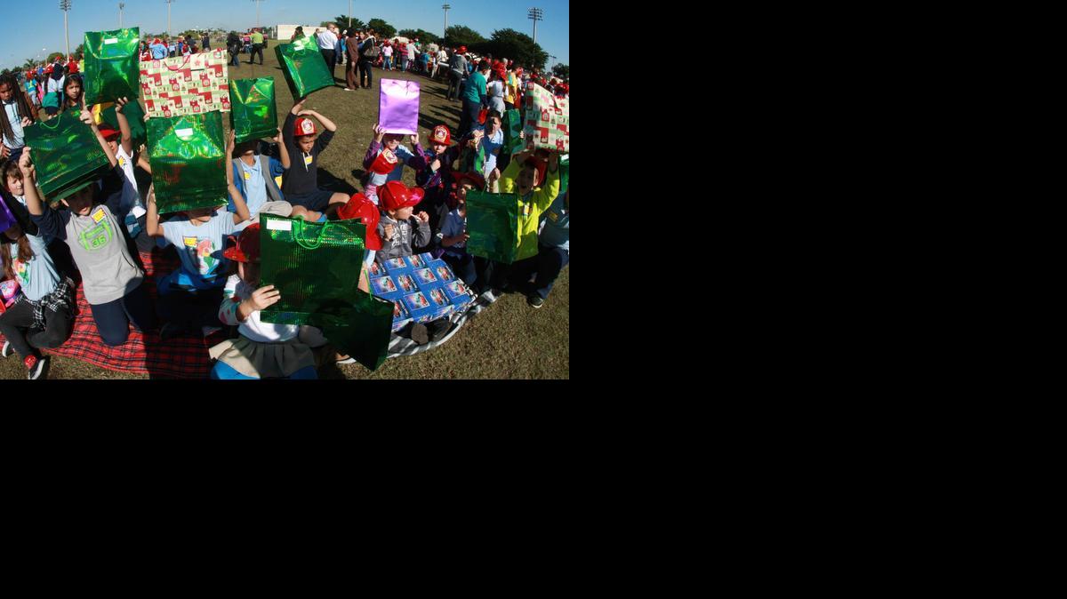 
Cientos de niños de bajos recursos recibieron el jueves juguetes y dulces en el parque Goodlet de Hialeah de parte de las autoridades y oficiales electos de esa ciudad. En la imagen, los pequeños muestran sus regalos.
