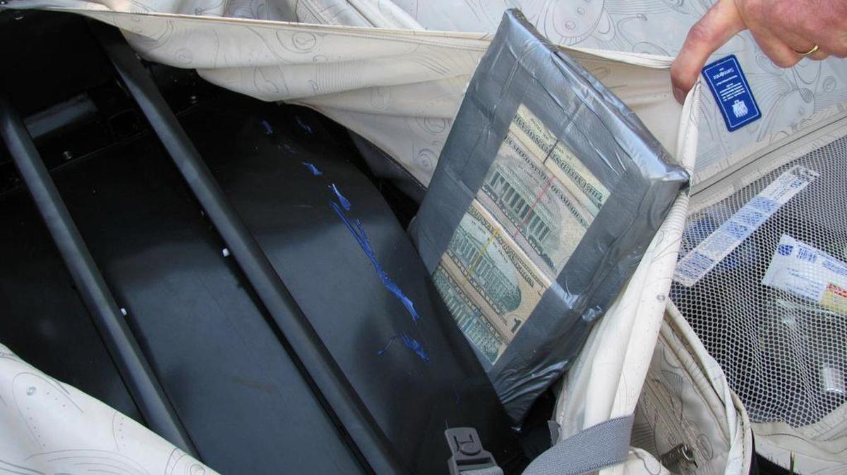 Dinero decomisado por agentes de ICE escondido en una maleta. Foto de archivo.