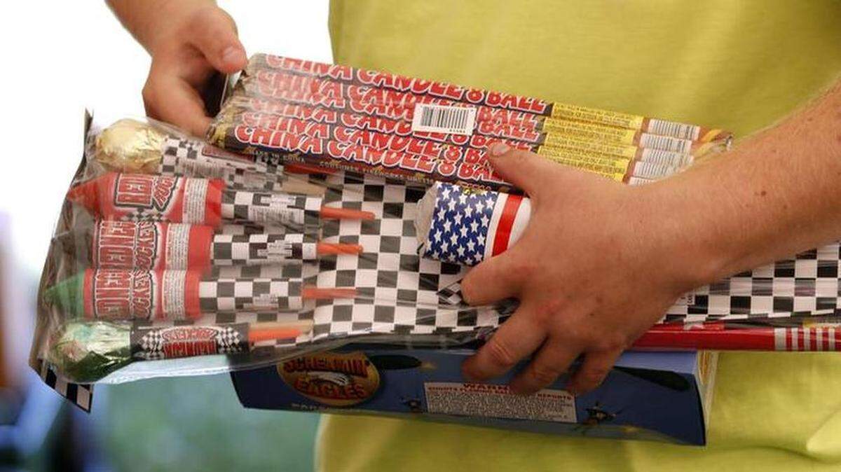 Un cliente sostiene paquetes de fuegos artificiales antes de comprarlos en una tienda en Adel, Iowa.