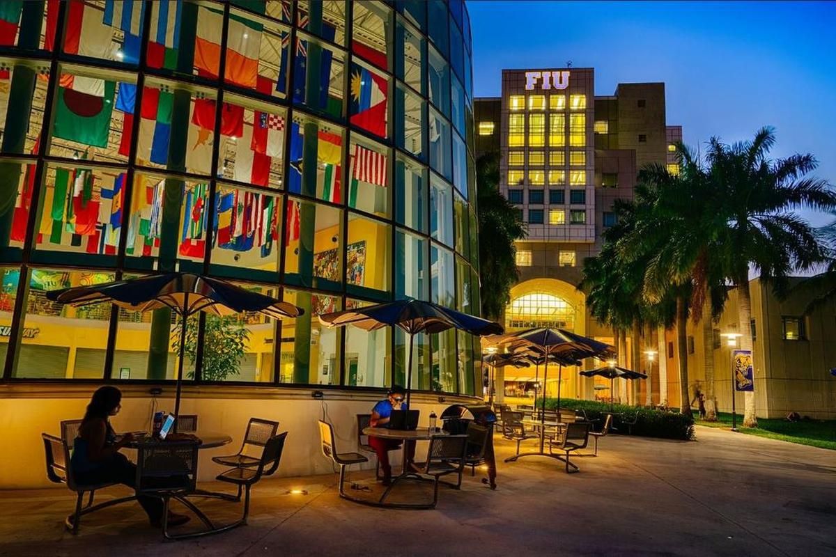 Estudiantes se ven usando sus computadores en un espacio abierto de la Universidad Internacional de la Florida (FIU).
