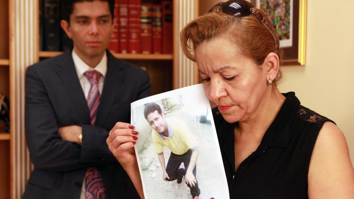 Jorge Rivera, abogado de inmigración en Miami, con María López, quien sostiene en sus manos una foto de su hijo Ever Mejía, el viernes, 24 de febrero del 2017.