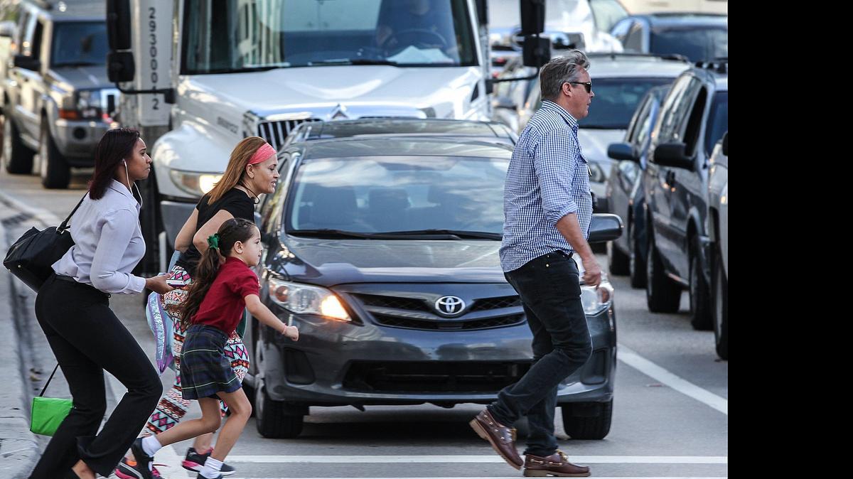 
Varios peatones cruzan la calle en medio del tráfico de la mañana, al sur del Puente de Brickell, el pasado 12 de mayo.


