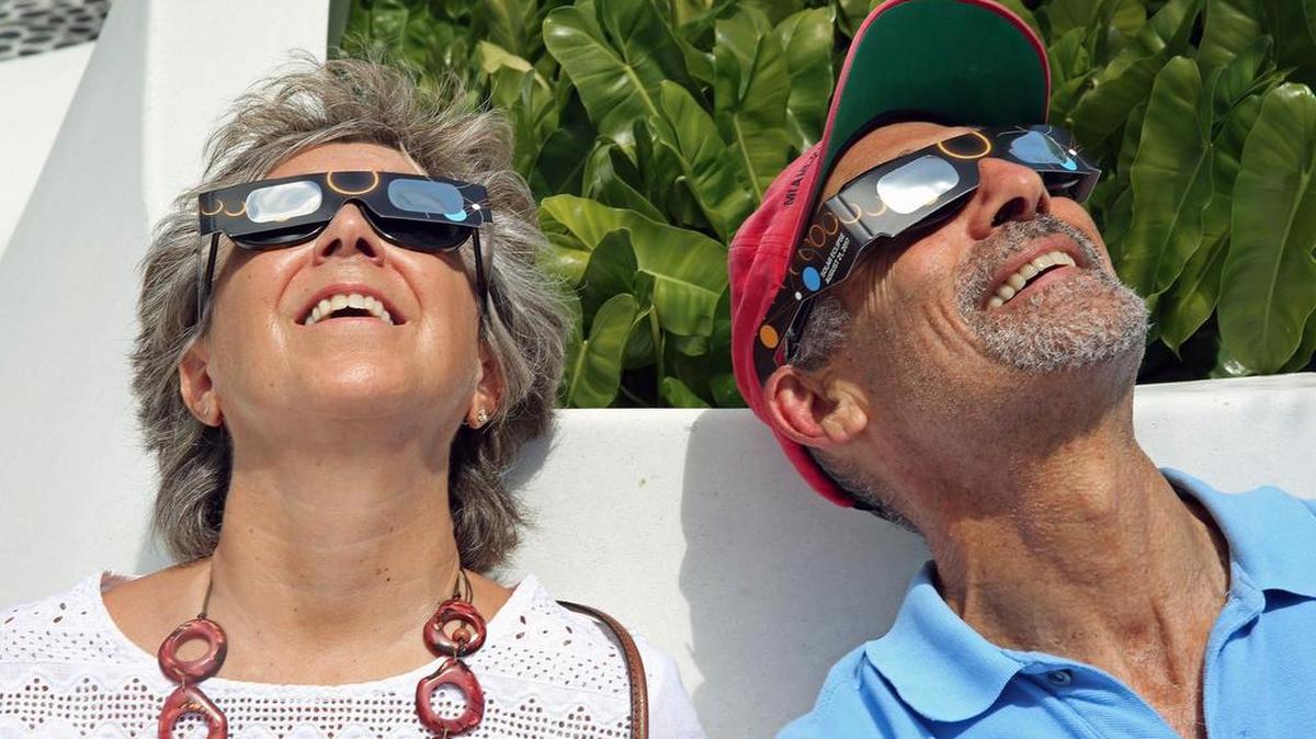Lynn Capaldo y Jonathan Katzen disfrutan del eclipse de sol en el Museo Frost en el centro de Miami, el lunes 21 de agosto de 2017.