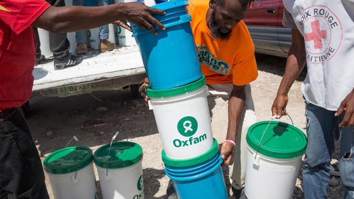 Miembros del equipo de emergencias de Oxfam que entregaron el domingo kits de higiene para evitar la propagación del cólera y otras enfermedades en la localidad de Camp Perrin, en el sur de Haití.