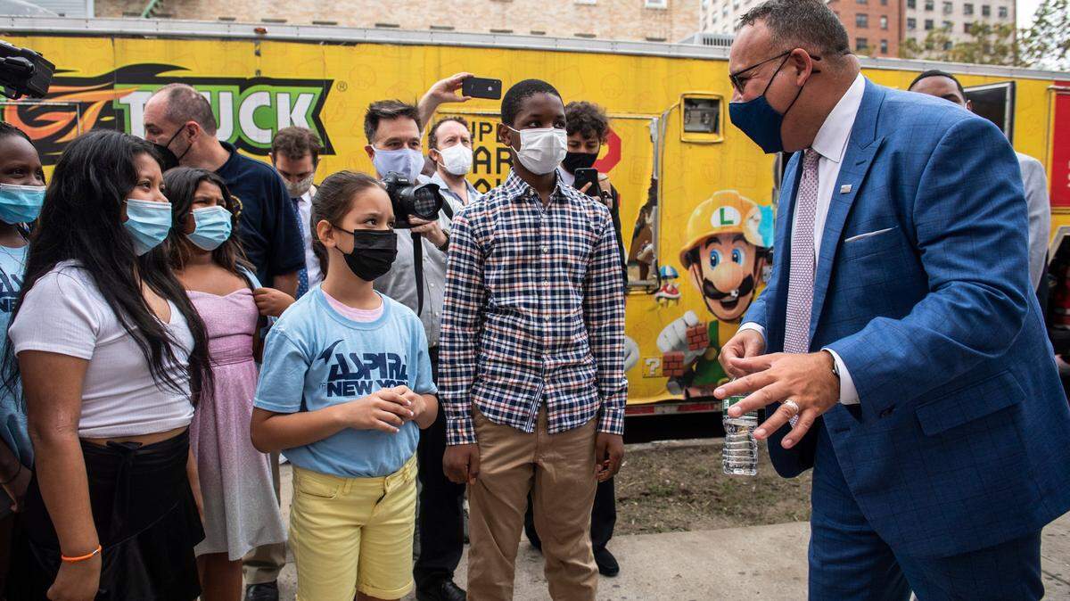 El secretario de Educación, Miguel Cardona, habla con varios estudiantes en el patio de la P.S. 5 Port Morris, una escuela primaria del Bronx, en Nueva York, el pasado 17 de agosto de 2021. Cardona pedirá este jueves 27 de enero un aumento de la financiación para las escuelas del Título I, las cuales reciben ayuda federal sobre la base de que el 40% o más de los estudiantes matriculados proceden de familias con bajos ingresos.
