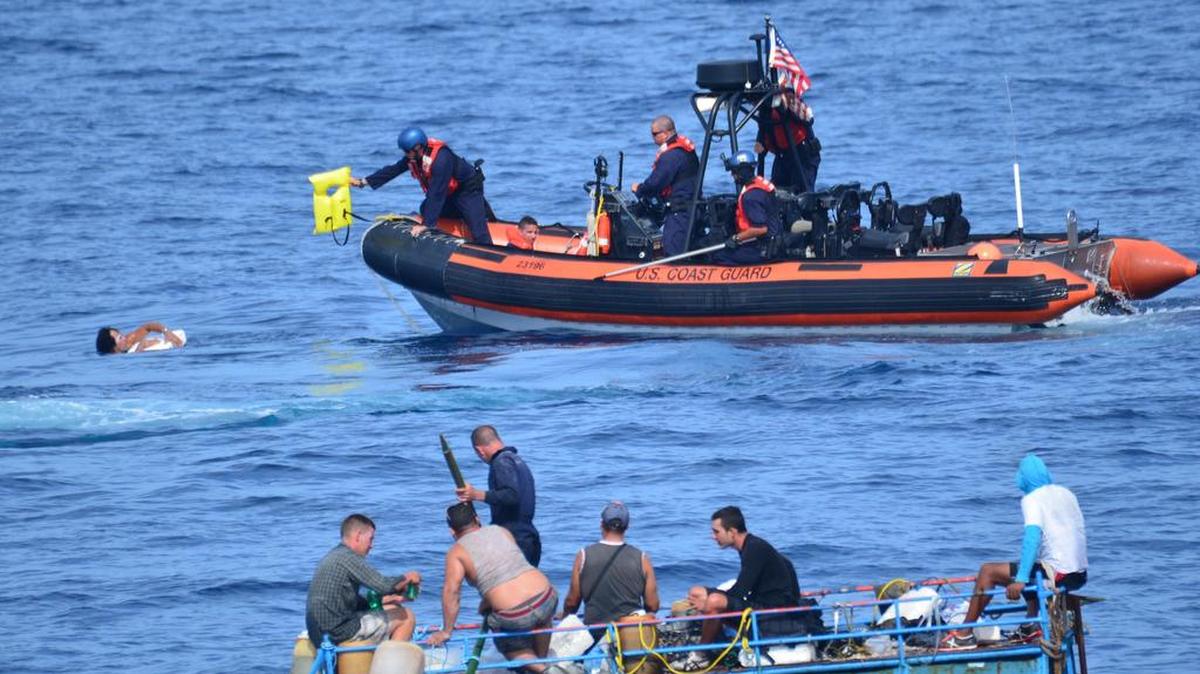 Foto de archivo. Un tripulante del escampavías Mohawk del Servicio de Guardacostas de EEUU da un salvavidas a un cubano que saltó al agua cerca de Cayo Hueso.